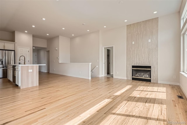 15870 Duckweed Ct, Parker, CO 80134 - unfurnished living room featuring recessed lighting, visible vents, light wood-style flooring, and a fireplace