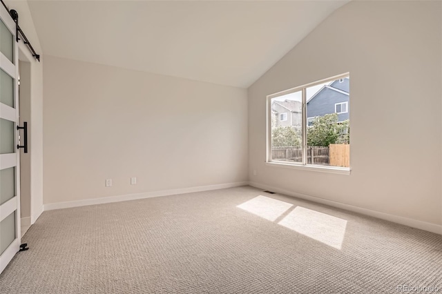 15870 Duckweed Ct, Parker, CO 80134 - carpeted spare room with baseboards, vaulted ceiling, and a barn door