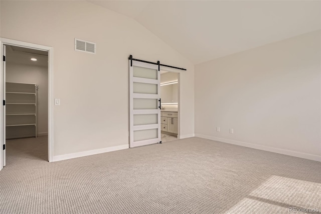 15870 Duckweed Ct, Parker, CO 80134 - unfurnished bedroom featuring visible vents, a barn door, a spacious closet, and light colored carpet