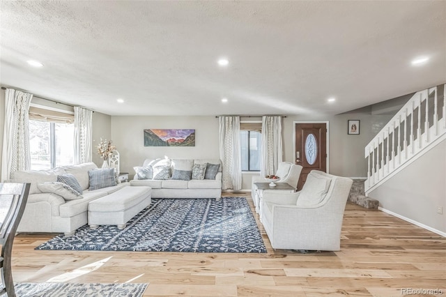 living room featuring a textured ceiling and light hardwood / wood-style floors