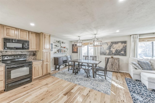 kitchen with black appliances, pendant lighting, light wood-type flooring, and a wealth of natural light