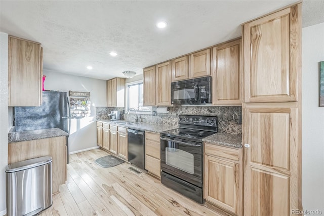 kitchen with light brown cabinets, sink, light hardwood / wood-style flooring, and black appliances