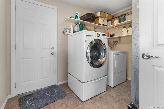 clothes washing area with independent washer and dryer and light tile patterned flooring