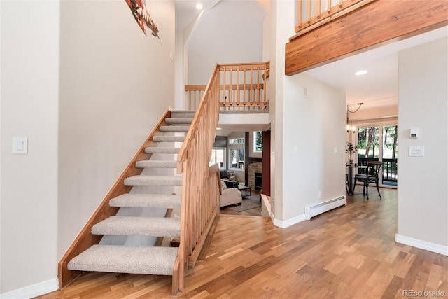 8171 S Homesteader Dr, Morrison, CO 80465 - stairway featuring a baseboard heating unit, wood finished floors, baseboards, and recessed lighting