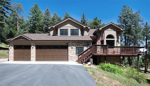 8171 S Homesteader Dr, Morrison, CO 80465 - view of front of house featuring stone siding, driveway, a deck, a shingled roof, and stairs