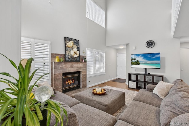8269 S Gaylord Cir, Centennial, CO 80122 - living area featuring a towering ceiling, a fireplace, and wood finished floors