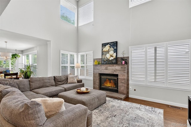 8269 S Gaylord Cir, Centennial, CO 80122 - living room with a high ceiling, a tiled fireplace, and wood finished floors