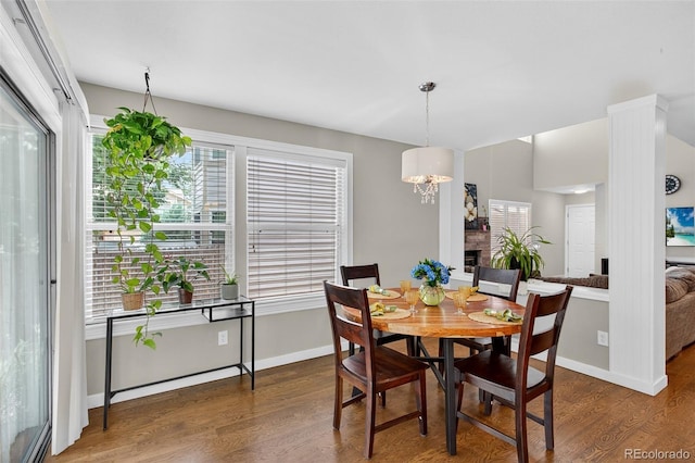 8269 S Gaylord Cir, Centennial, CO 80122 - dining room featuring wood finished floors, a fireplace, and a chandelier