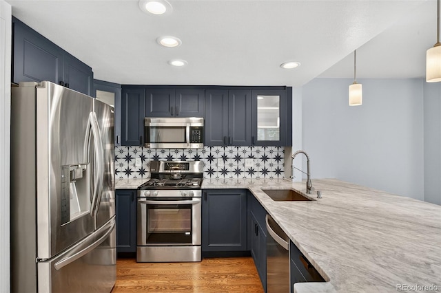 8269 S Gaylord Cir, Centennial, CO 80122 - kitchen with stainless steel appliances, glass insert cabinets, light wood-style flooring, light stone counters, and backsplash
