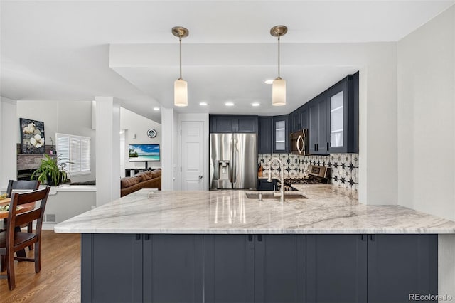 8269 S Gaylord Cir, Centennial, CO 80122 - kitchen featuring appliances with stainless steel finishes, a peninsula, backsplash, light stone counters, and recessed lighting