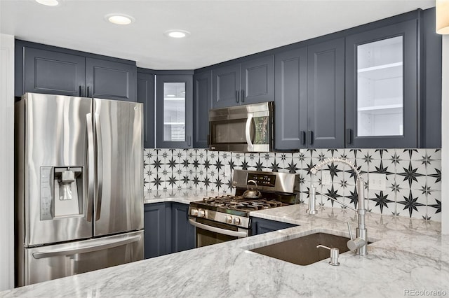 8269 S Gaylord Cir, Centennial, CO 80122 - kitchen featuring appliances with stainless steel finishes, light stone countertops, tasteful backsplash, glass insert cabinets, and recessed lighting