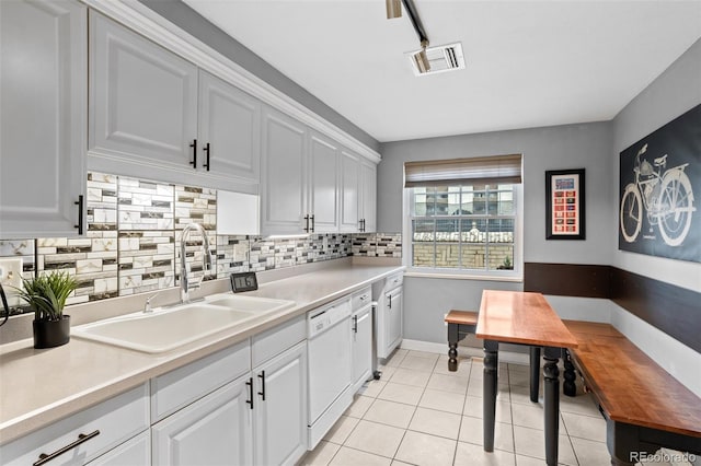 kitchen featuring light tile patterned floors, visible vents, a sink, light countertops, and tasteful backsplash