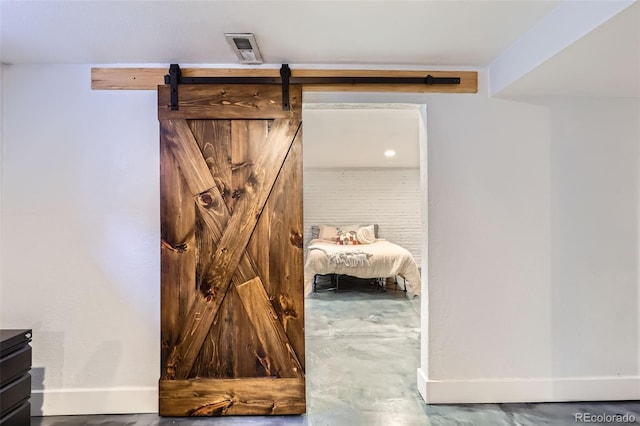 interior space with visible vents, baseboards, and a barn door