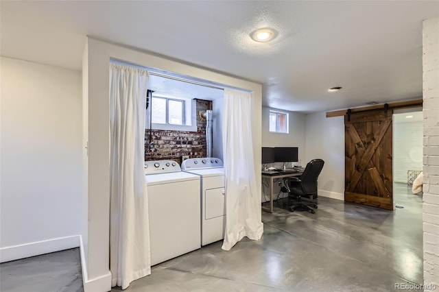 washroom with laundry area, independent washer and dryer, baseboards, and a barn door