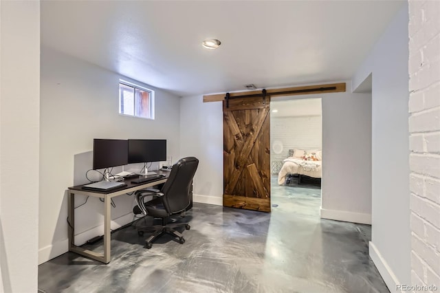 office area with visible vents, finished concrete flooring, baseboards, and a barn door