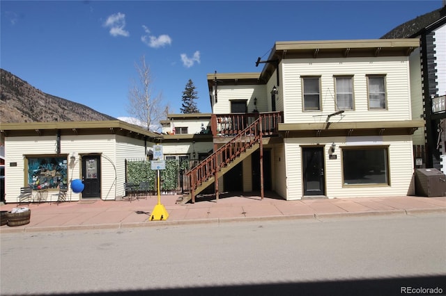 view of front facade with a deck with mountain view and a patio