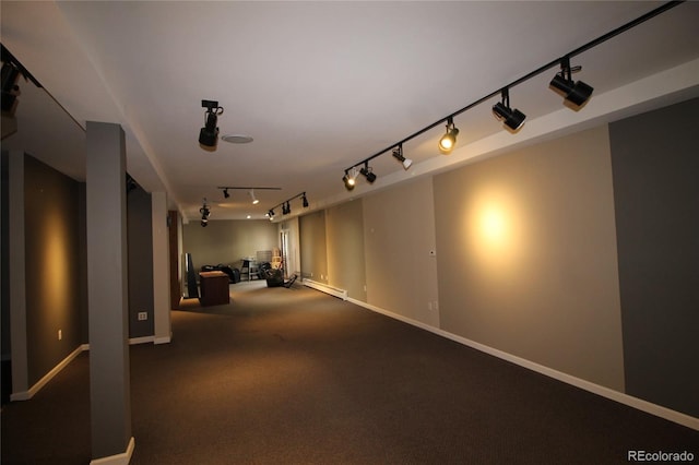 interior space with carpet, track lighting, and a baseboard heating unit