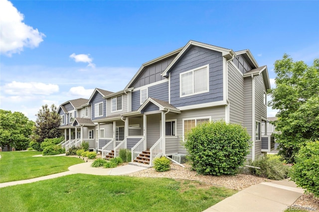 19216 E Idaho Pl Unit 102, Aurora, CO 80017 - view of front of house featuring board and batten siding, a front lawn, and cooling unit