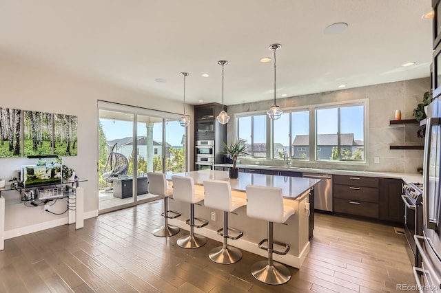 4526 Colorado River Dr, Firestone, CO 80504 - kitchen featuring appliances with stainless steel finishes, dark brown cabinets, a breakfast bar area, a center island, and a sink