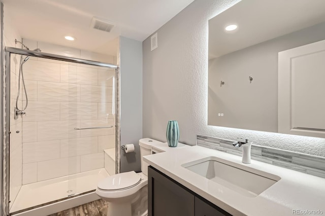 4526 Colorado River Dr, Firestone, CO 80504 - bathroom with toilet, vanity, a stall shower, wood finished floors, and recessed lighting