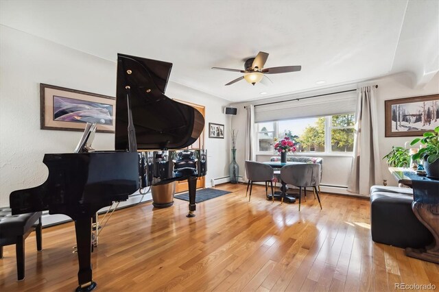 sitting room featuring ceiling fan, hardwood / wood-style floors, and a baseboard heating unit