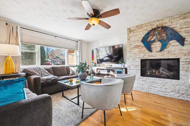 living room featuring a fireplace, hardwood / wood-style flooring, and ceiling fan