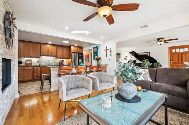 living room with light hardwood / wood-style floors and ceiling fan