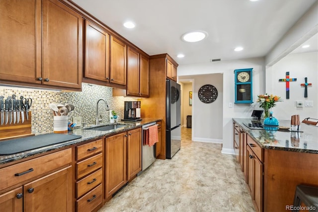 kitchen with backsplash, dark stone countertops, sink, and black appliances