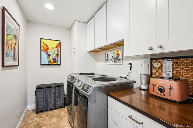 clothes washing area featuring washer and dryer and cabinets