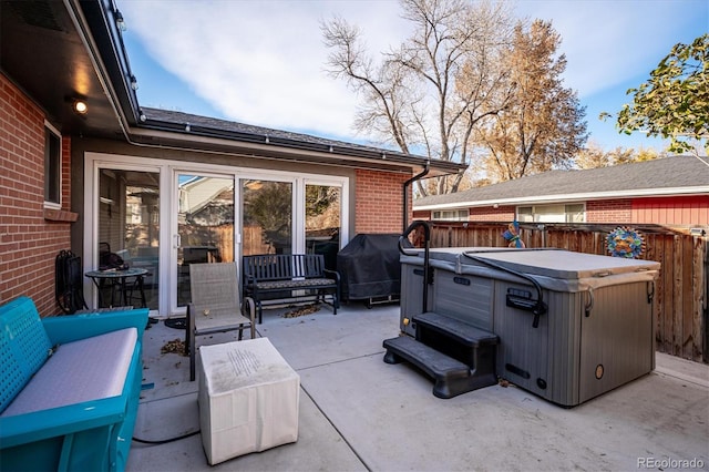 view of patio / terrace with grilling area, an outdoor hangout area, and a hot tub