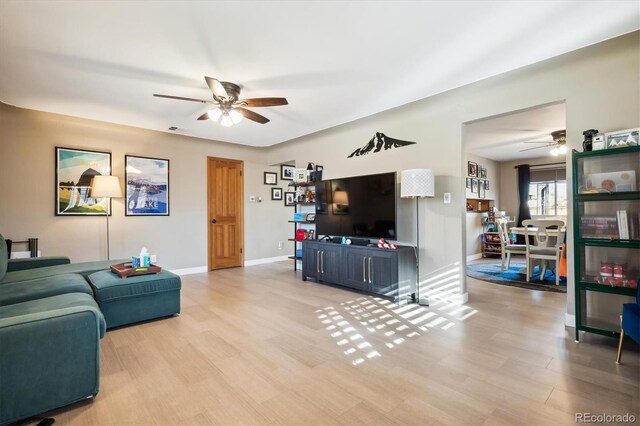 living room featuring light hardwood / wood-style floors and ceiling fan