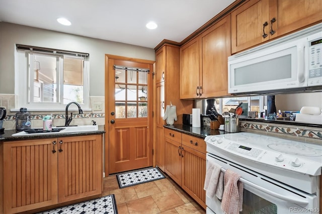 kitchen featuring white appliances and dark stone counters