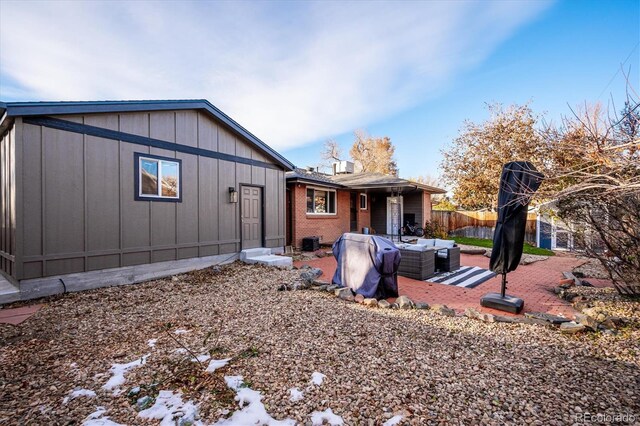 back of property with outdoor lounge area and a patio area