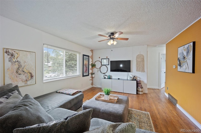 7118 Metropolitan St, Colorado Springs, CO 80911 - living area featuring ceiling fan, a textured ceiling, baseboards, wood finished floors, and visible vents