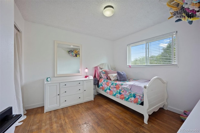 7118 Metropolitan St, Colorado Springs, CO 80911 - bedroom featuring baseboards, a textured ceiling, and wood finished floors