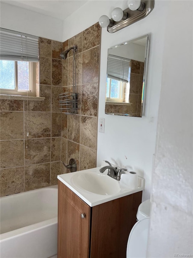 full bathroom with vanity, toilet, and tiled shower / bath combo