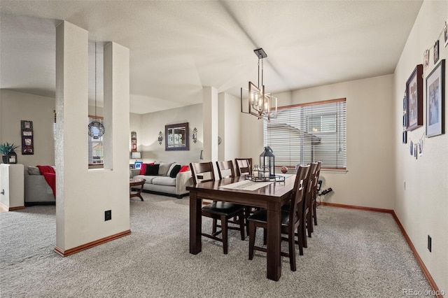 carpeted dining area featuring an inviting chandelier