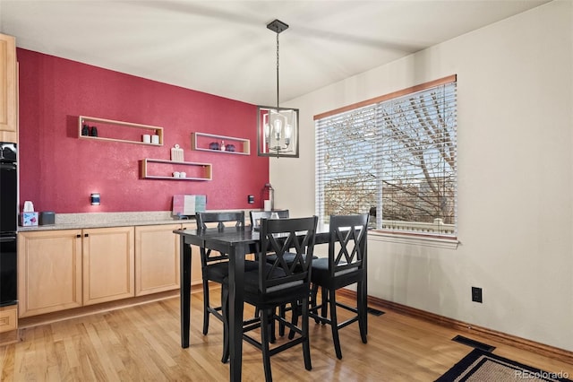 dining space featuring a notable chandelier and light hardwood / wood-style floors