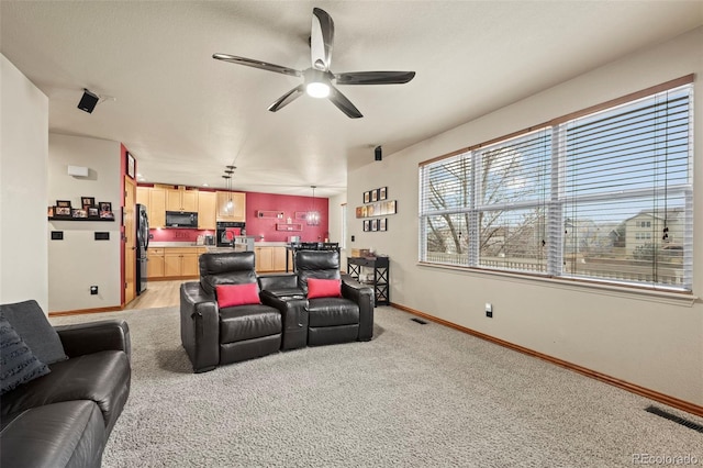 carpeted home theater with ceiling fan