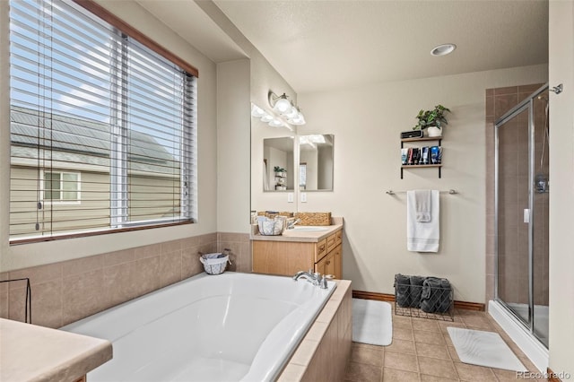 bathroom featuring tile patterned flooring, vanity, and shower with separate bathtub