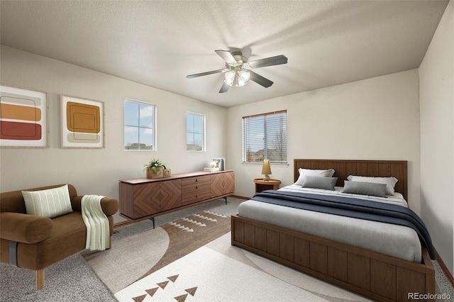 bedroom with a textured ceiling, ceiling fan, and light carpet