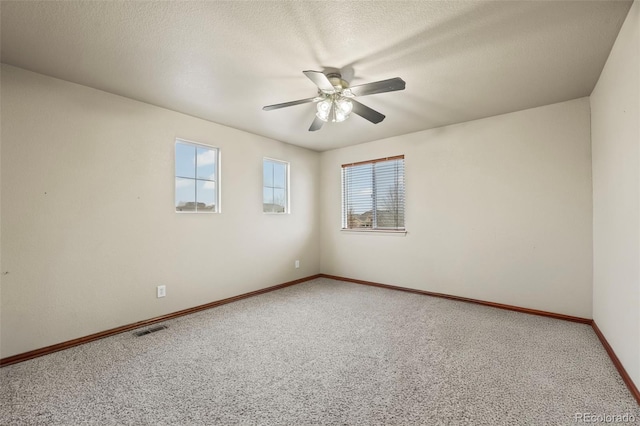 carpeted empty room featuring ceiling fan and a textured ceiling