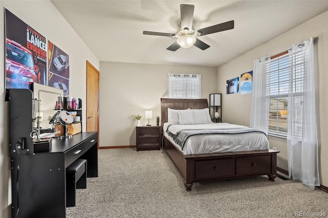 carpeted bedroom featuring ceiling fan and a textured ceiling