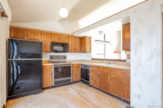 kitchen featuring pendant lighting, sink, black appliances, and lofted ceiling