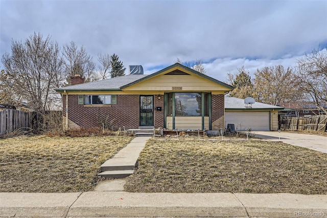 view of front of home featuring fence, concrete driveway, and brick siding