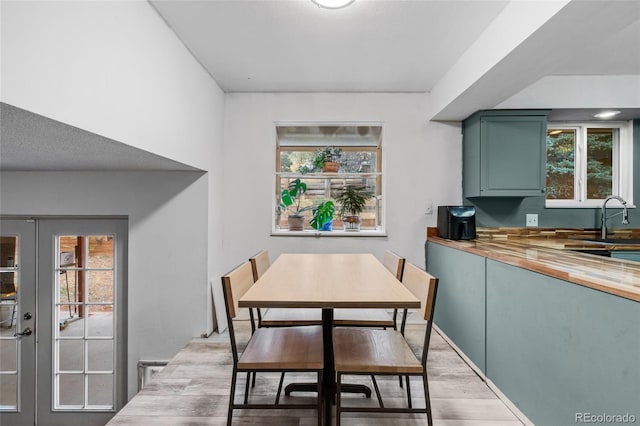 dining space featuring french doors and light hardwood / wood-style floors