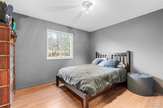 bedroom featuring a textured ceiling and light wood-type flooring