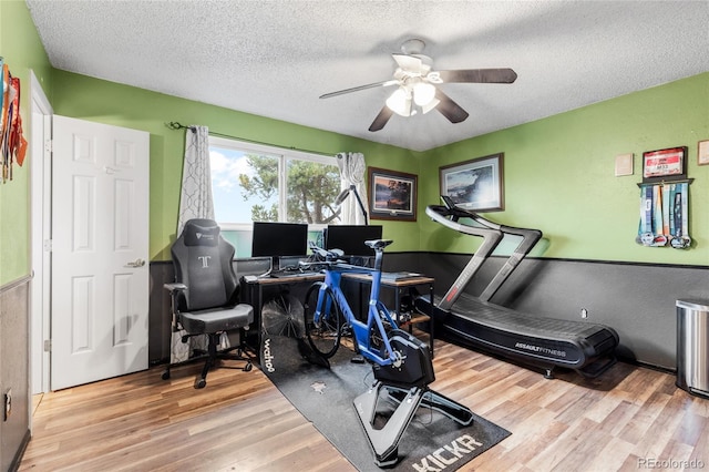 home office featuring a textured ceiling, hardwood / wood-style flooring, and ceiling fan