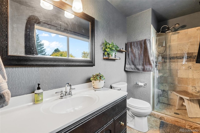 bathroom featuring vanity, toilet, and a shower with shower door