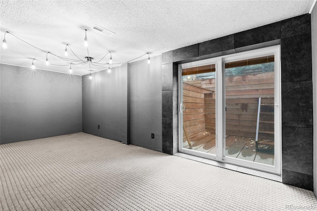 empty room featuring light carpet and a textured ceiling